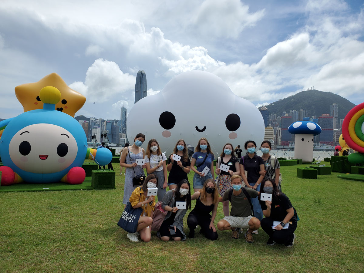 HKBU students wearing protective face coverings pose in front of a large inflatable cloud at the International Festival