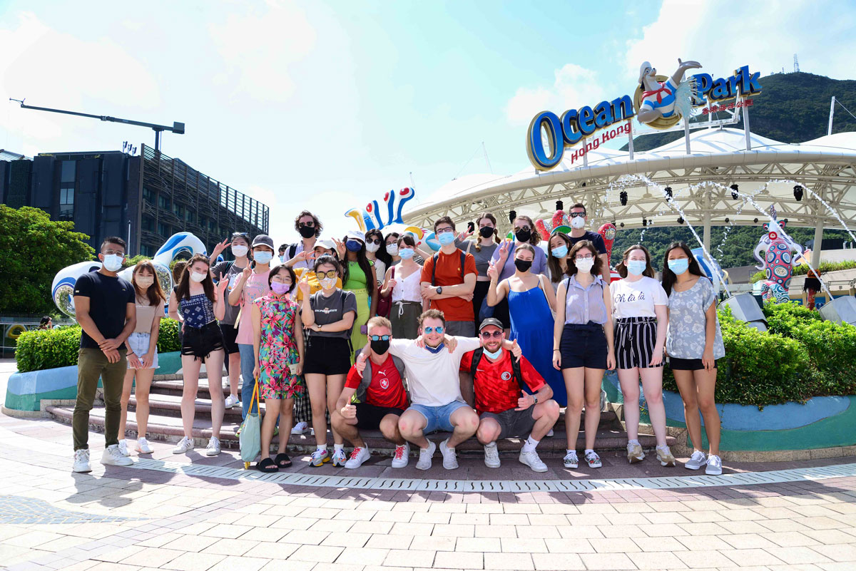 HKBU students smile and pose in front of the Ocean Park sign